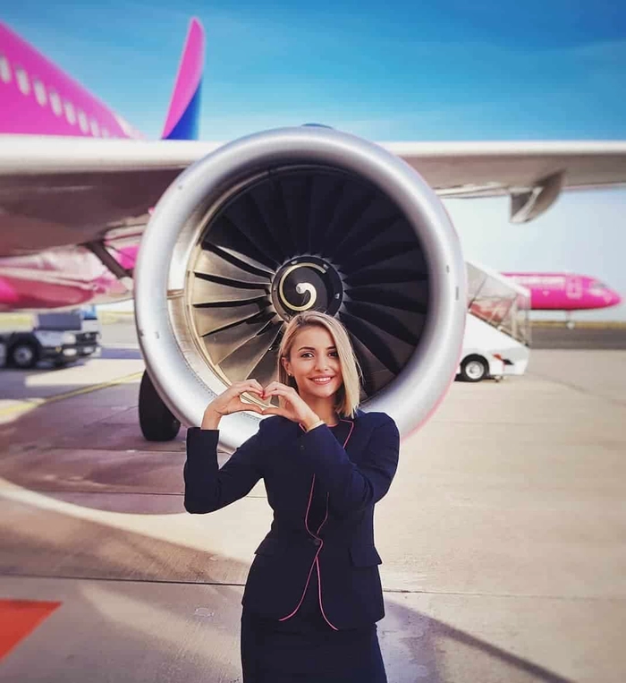 o femeie blonda langa motorul exterior al unui avion