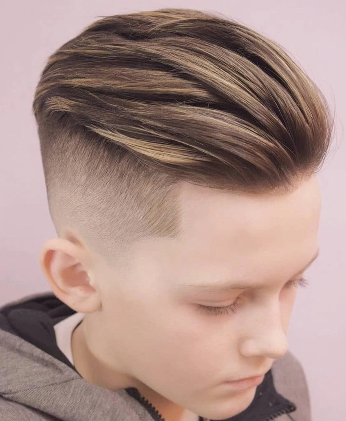 baiat pe un scaun la salon cu o noua tunsoare