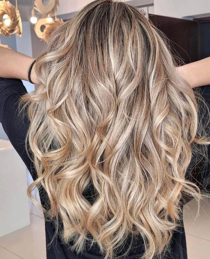femeie care tine mainele in parul ei blond