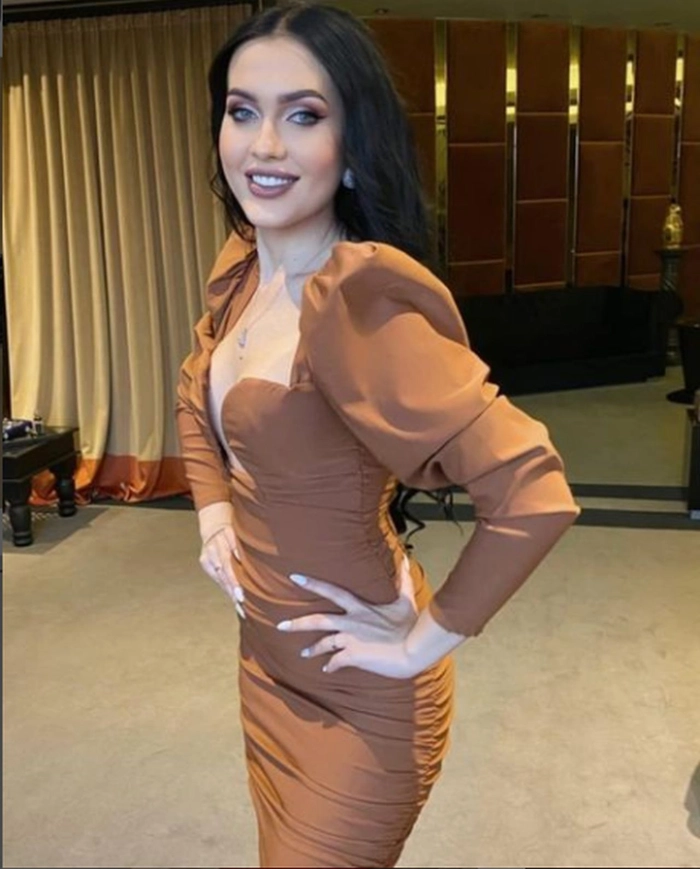 comanici bianca in rochie mulata in timp ce zambeste