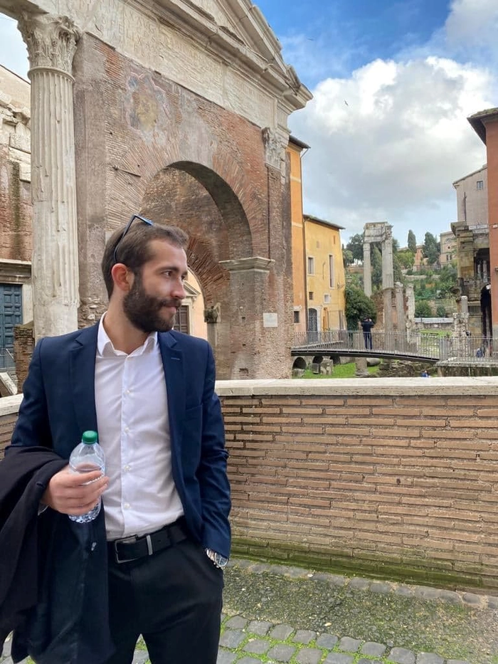  un barbat langa o cladire istorică din Roma
