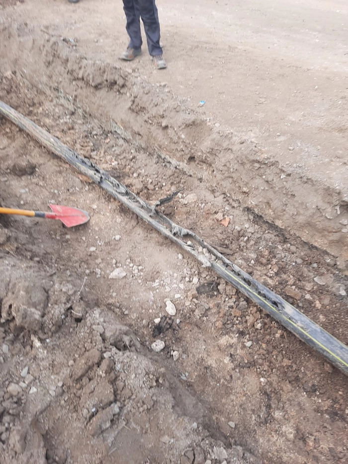 persoana in fata unei gropi cu o conducta