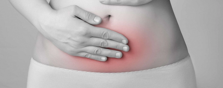 grafica femeie care se tine de burta din cauza durerii provocate de vaginoza
