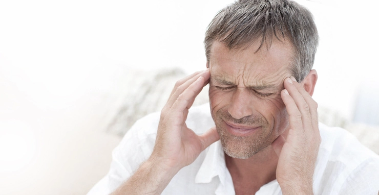 barbat care se tine de cap din cauza migrenei