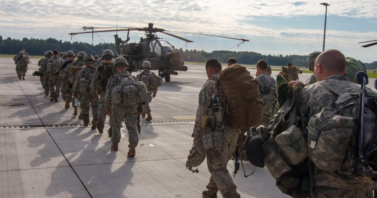 NATO trimite trupe în estul Europei, militari ce se imbarca intr-un elicopter