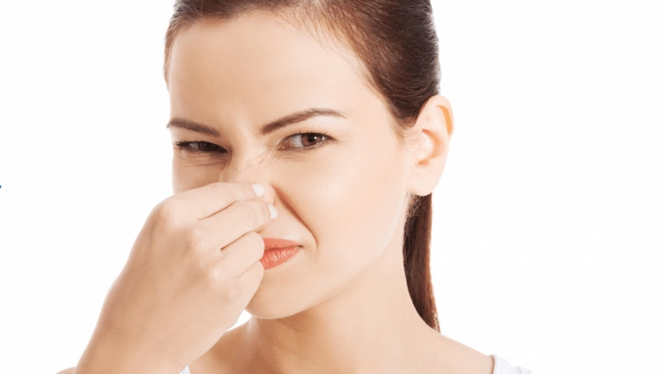 femeie care se tine de nas din cauza mirosului urat
