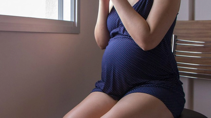femeie însărcinată îmbrăcată în rochie bleumarin