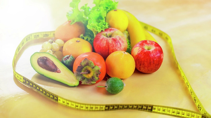 mai multe legume si fructe inconjurate de un metru pe o masa