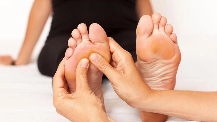 persoana care efectuiaza masaj la nivelul degetelor de la picioare unei alte persoane