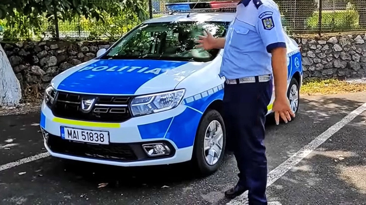 un politist langa o masina de politie