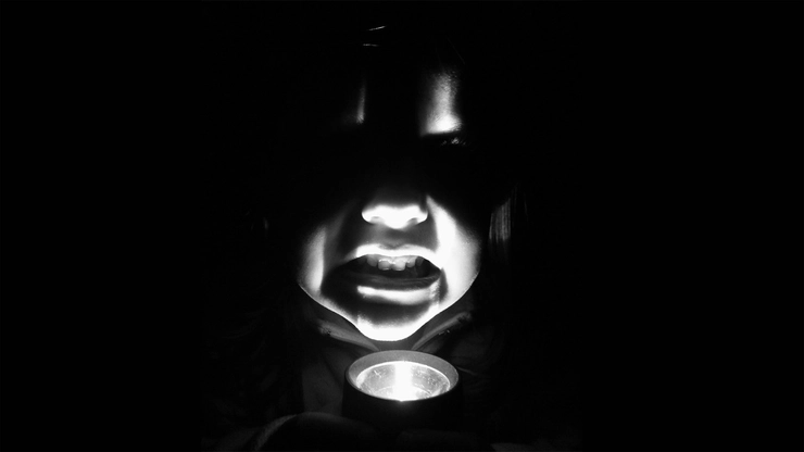 un copil cu lanterna aprinsă sub bărbie