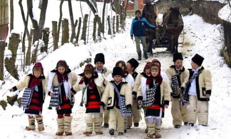 un grup de copii imbracati in costume populare
