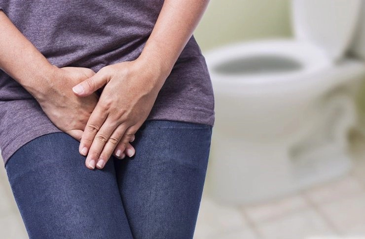 femeie care se tine de zona intima din cauza incontinentei urinare