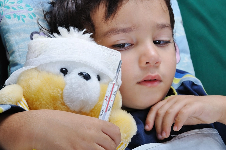 un copil bolnav cu o jucărie în brațe