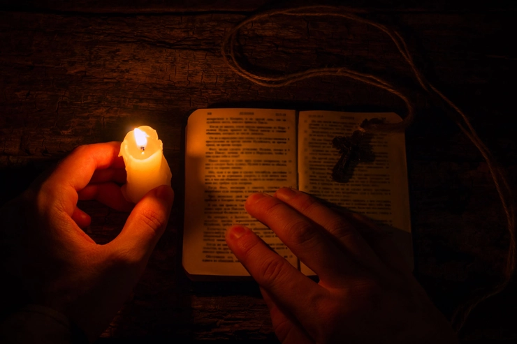 o lumânare, o carte de rugăciuni și o cruce