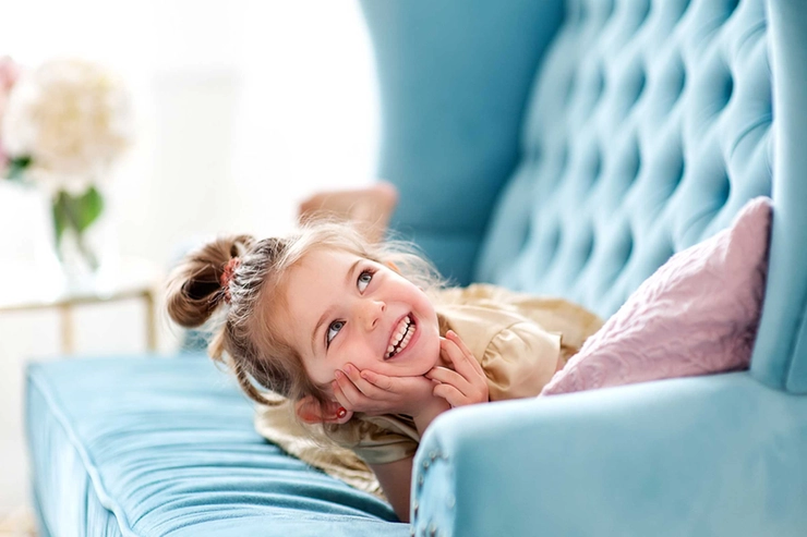un copil care râde pe pat
