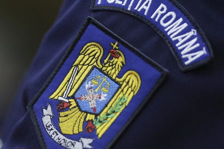 o persoană condusă la sediul Poliţiei, stema Romaniei de pe uniforma unui agent de politie