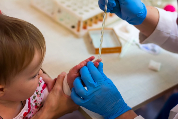 medic care ia o proba de sange din degetul unui copil