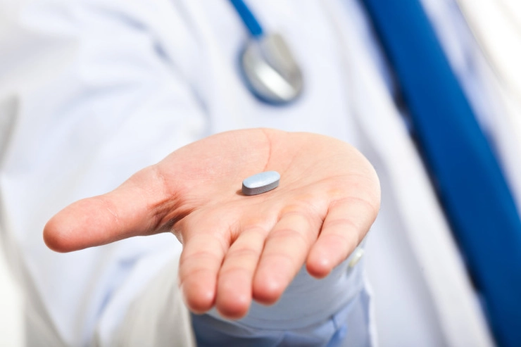 medic care intinde unui pacient o pastila