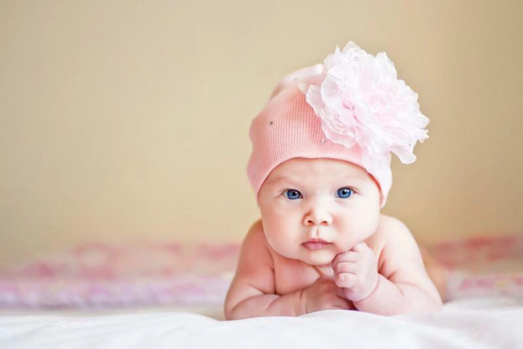 un bebelus cu o caciula in cap