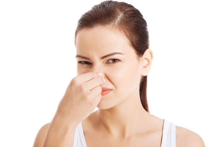 femeie care isi astupa nasul din cauza mirosului urat