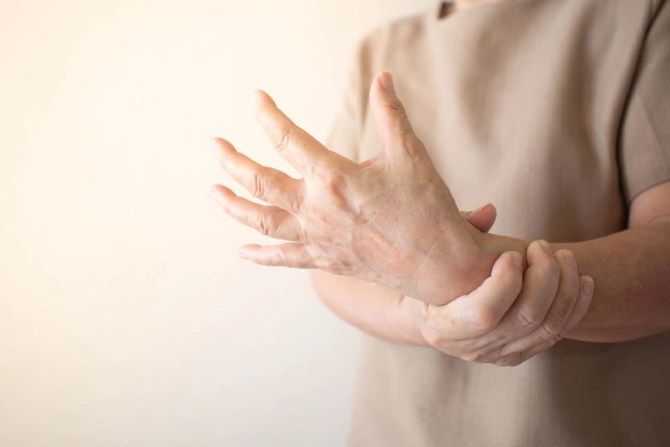 femeie care se tine de incheietura mainii din cauza durerii
