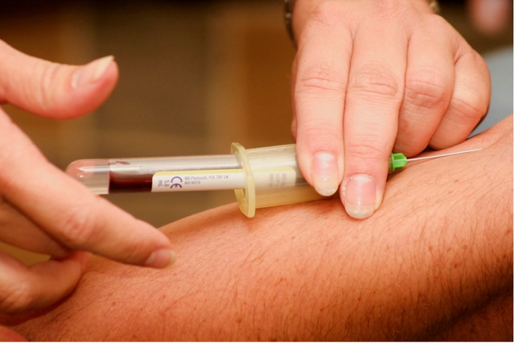 medic care ia o proba de sange unei persoane cu seringa din vena
