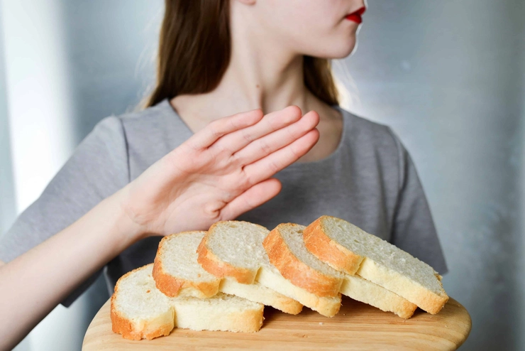 femeie care impinge cu mana o farfurie cu paine
