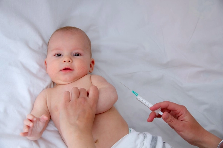 Un medic vaccineaza un copil