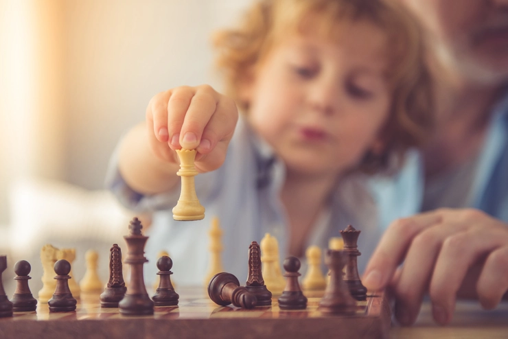 un copil care joacă șah
