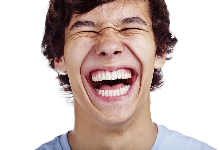 un băiat care râde cu gura până la urechi
