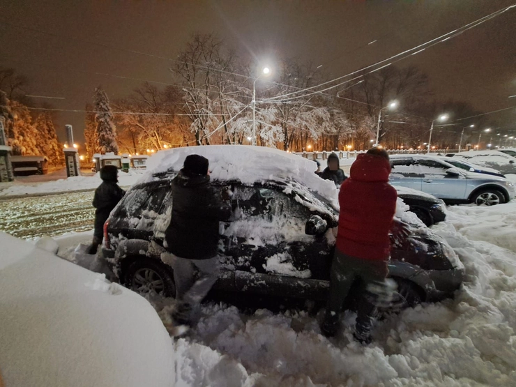 o poză cu patru băieți ajutând o mașină să iasă