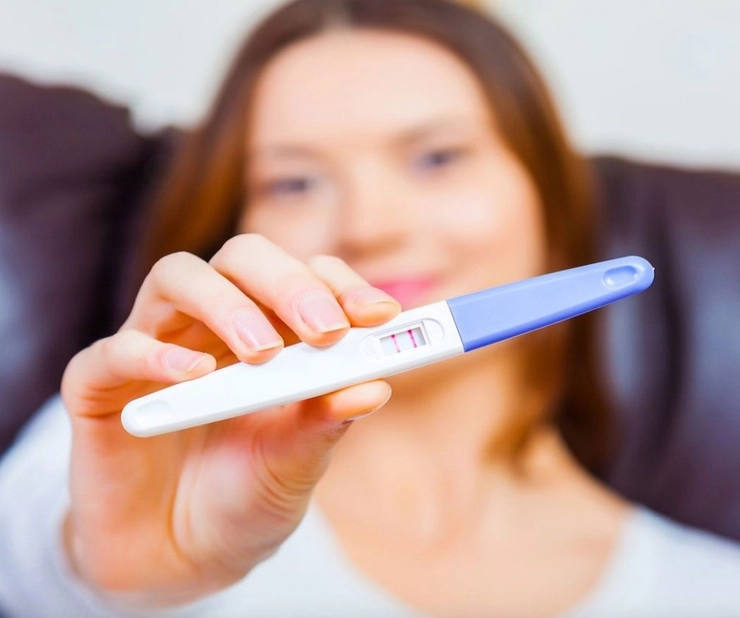 femeie ce arata un test de sarcina pozitiv