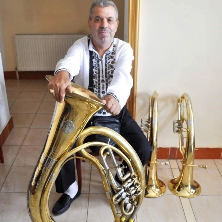 poză cu Constantin Lucan, coordonatorul fanfarei, în vârstă de 73 de ani