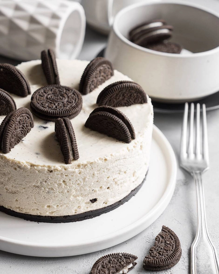 un cheesecake cu oreo pe o farfurie langa o furculita