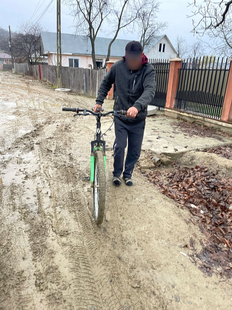 barbat cu bicicleta pe un drum innamolit